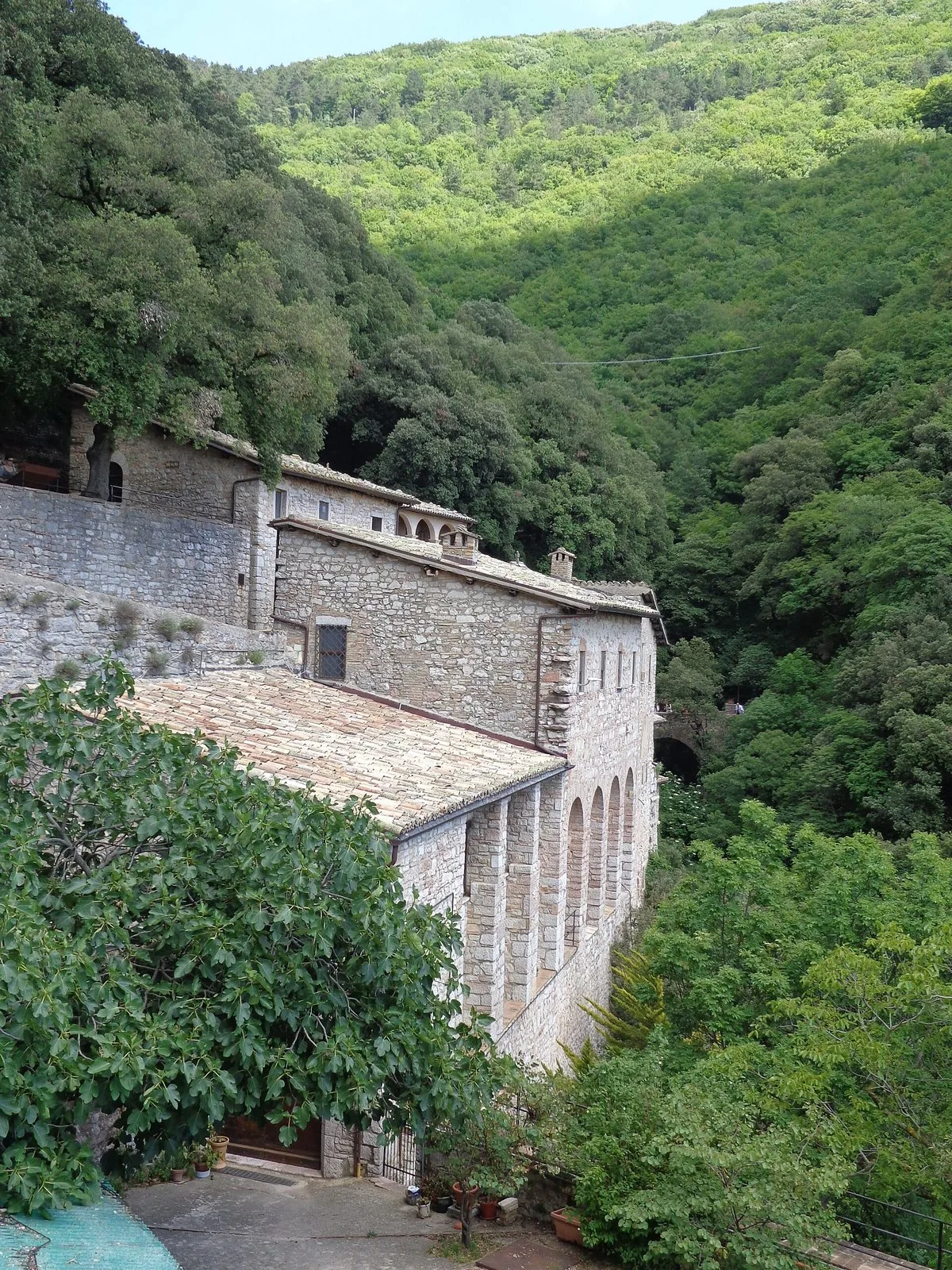 L'Eremo delle Carceri addossato alla roccia, nel bosco del Monte Subasio